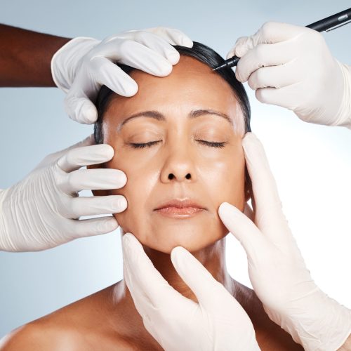 Woman, face and hands with pen for plastic surgery, beauty or cosmetic process by studio background.